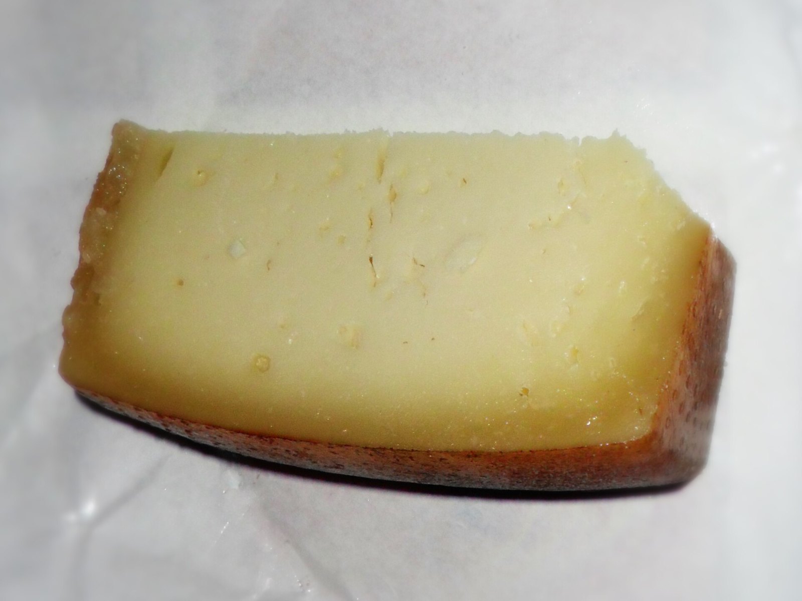 Spicchio di caprino stagionato con crosta sottile e pasta compatta