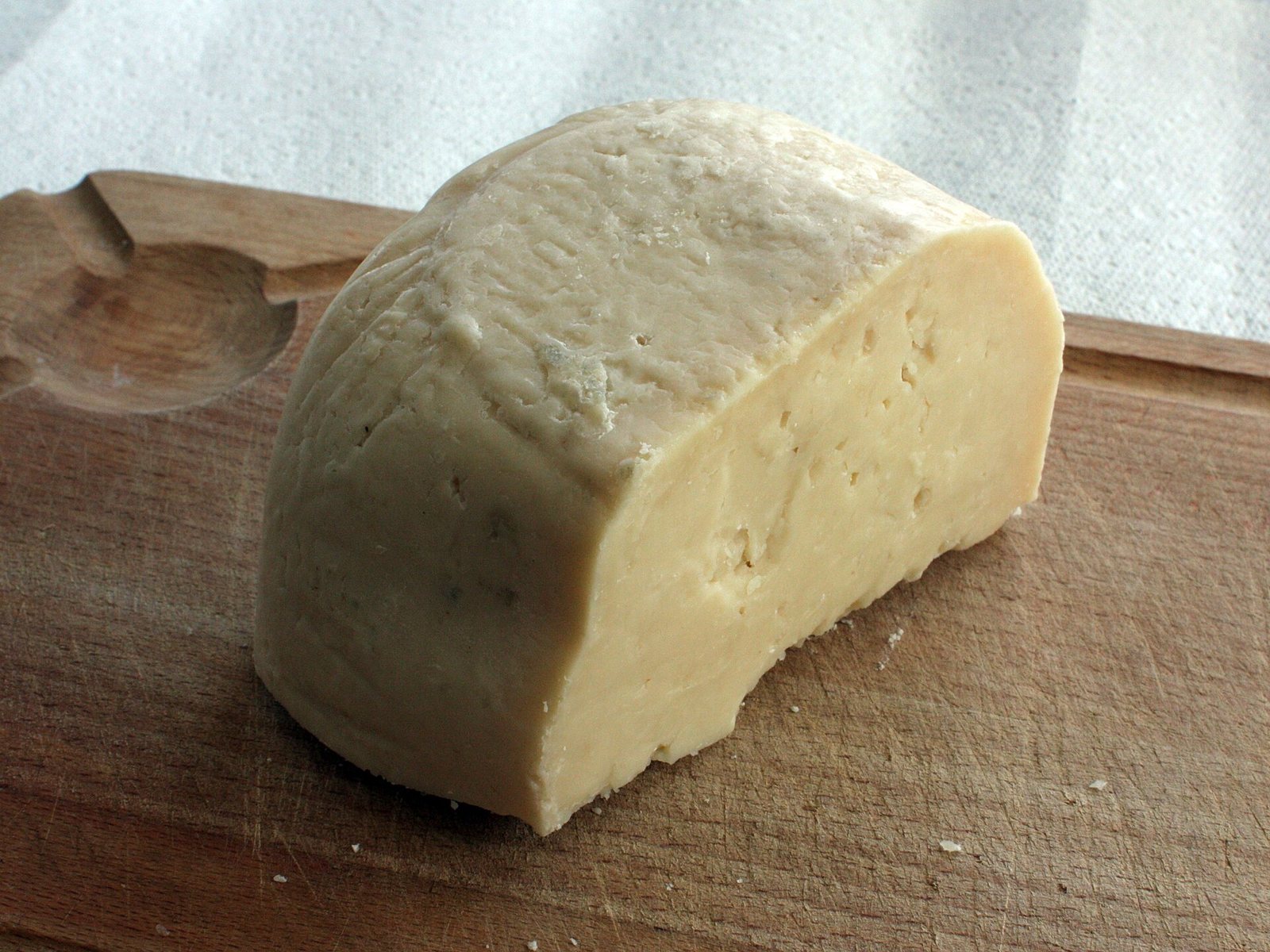 Forma di formaggio di fossa con la superficie irregolare, su un tagliere
