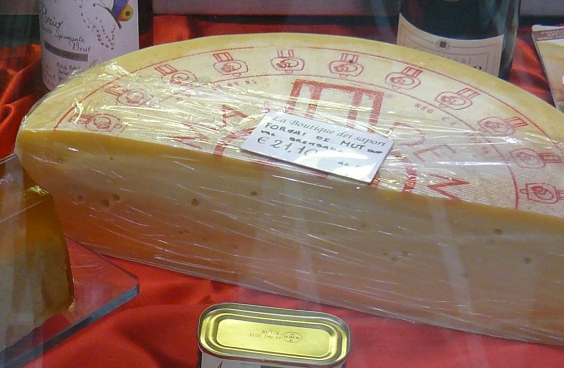 Forma di Formai de Mut dell’Alta Valle Brembana esposta al banco, con il cartellino