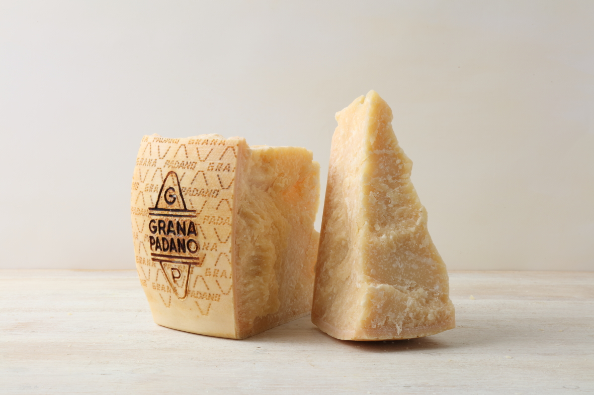 Due spicchi di Grana Padano DOP con la marchiatura sulla crosta