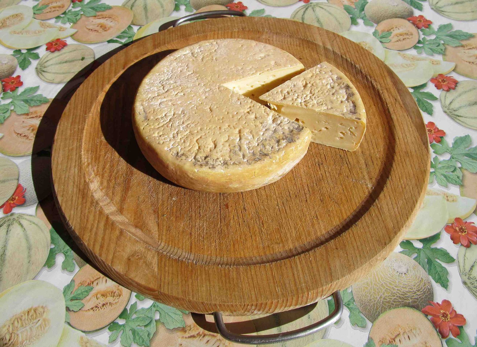 Forma intera e spicchio di Maccagno con pasta paglierina compatta e crosta sottile