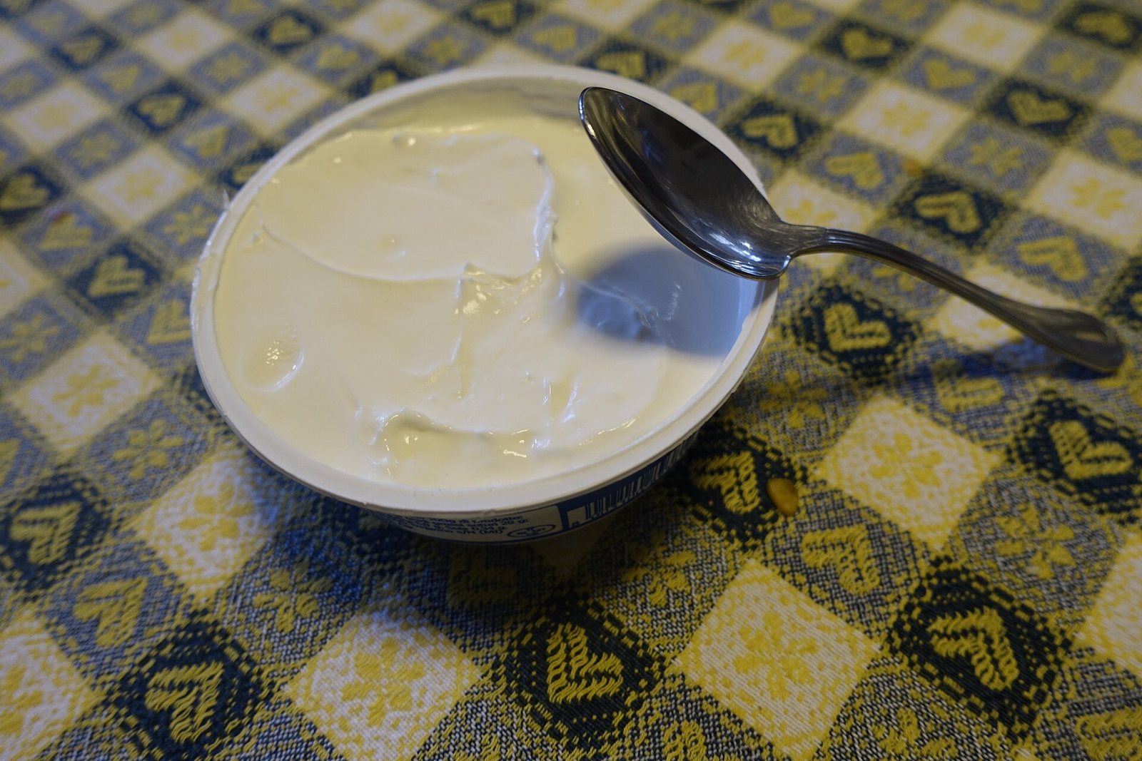 Mascarpone in una vaschetta aperta con un cucchiaio