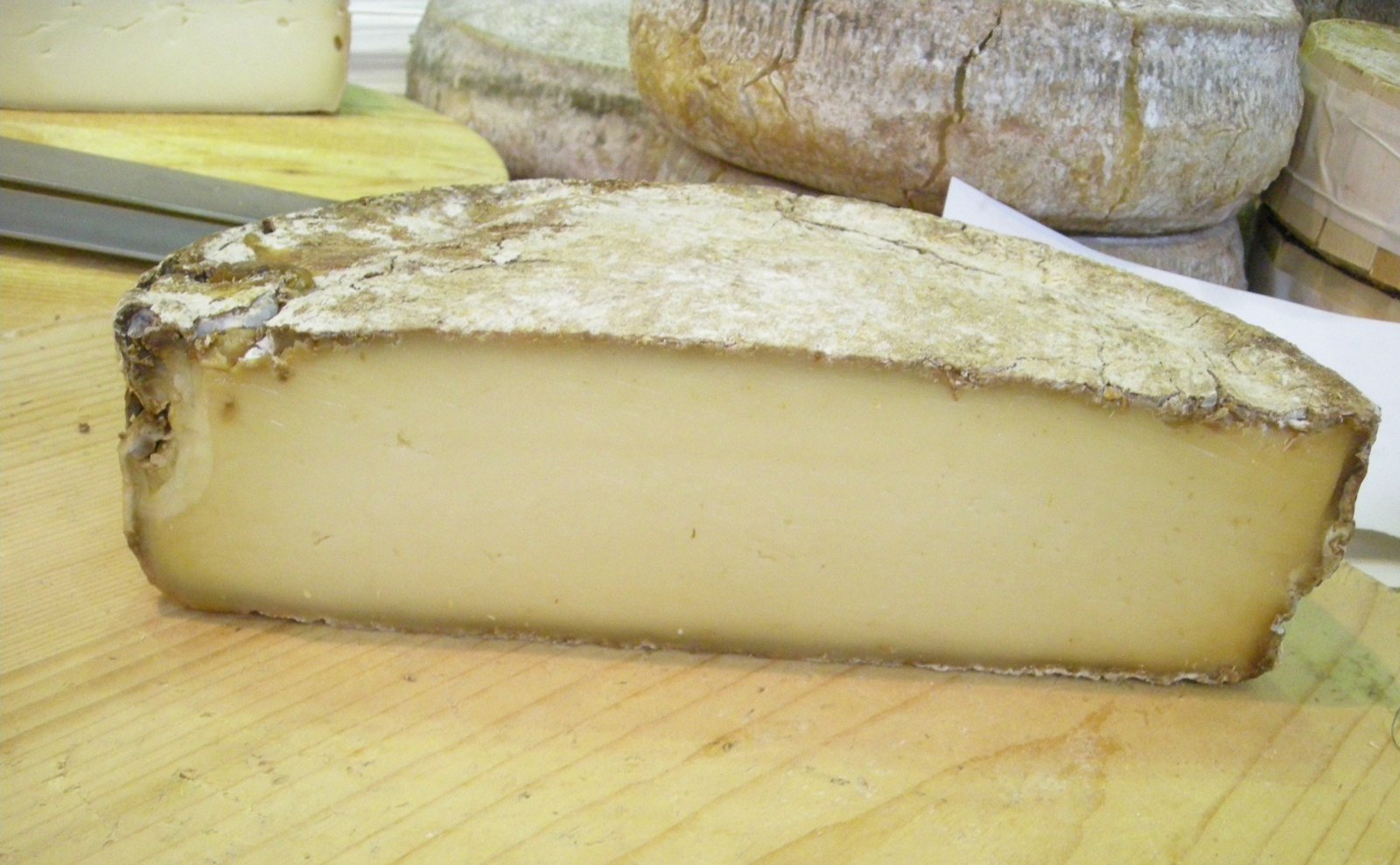 Mezza forma di Morlacco del Grappa stagionato con pasta paglierina compatta e crosta rugosa