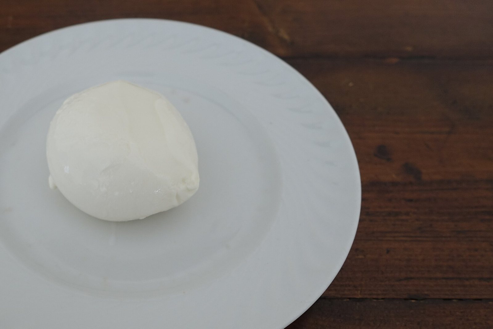 Una mozzarella fior di latte intera su un piatto bianco