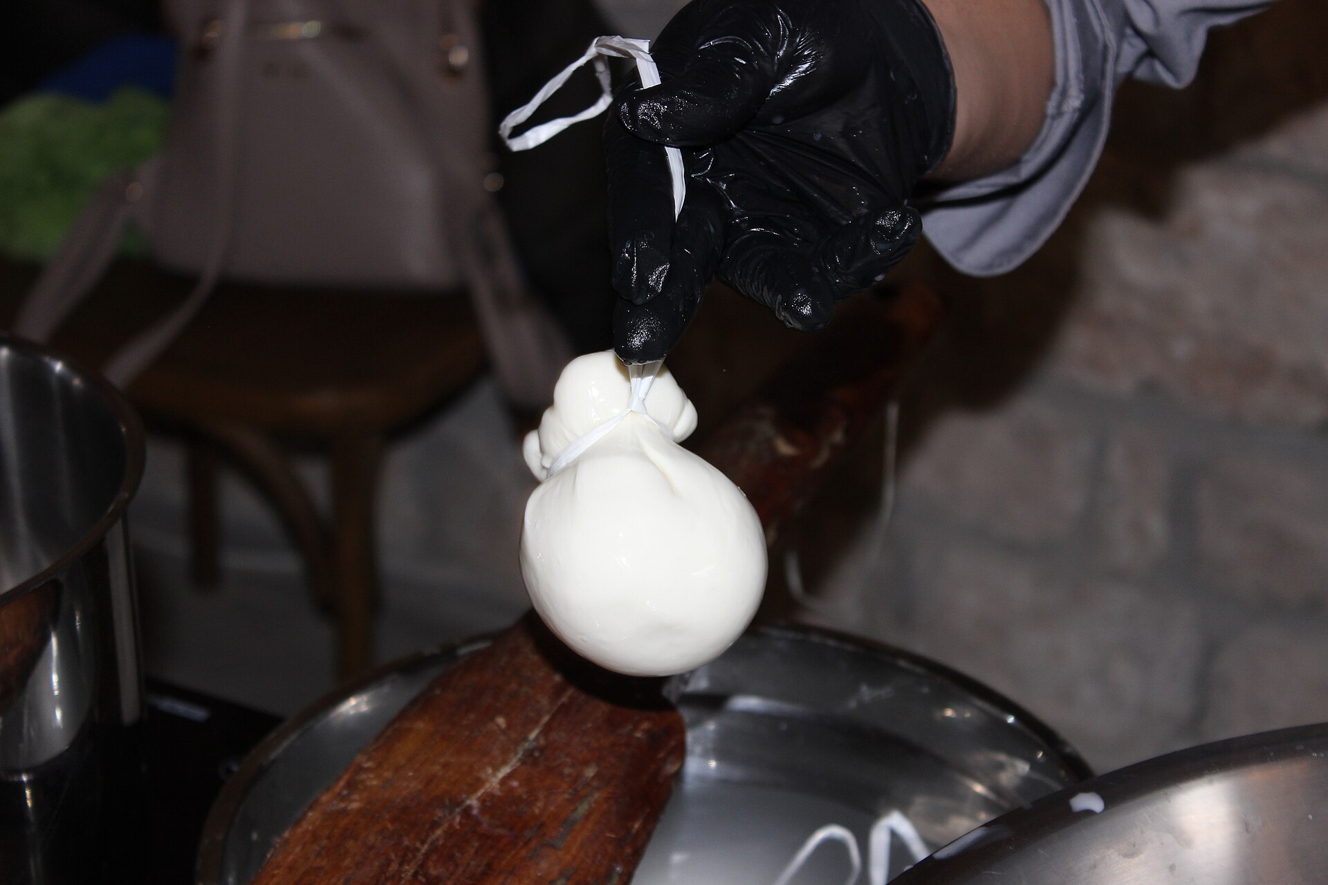 Il casaro lega una provola fresca appena modellata