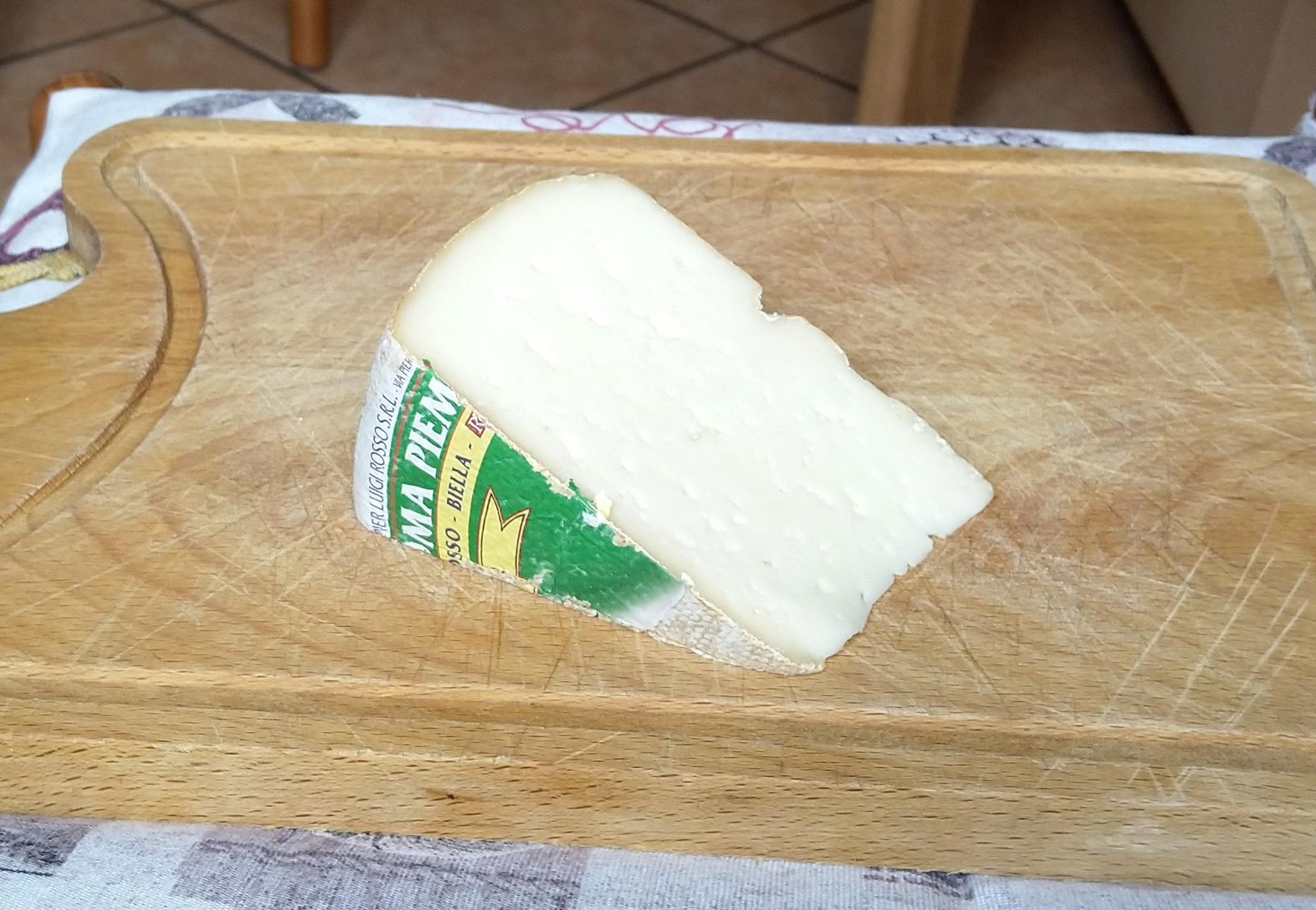 Forma e spicchio di Toma Piemontese DOP con pasta morbida e occhiatura minuta