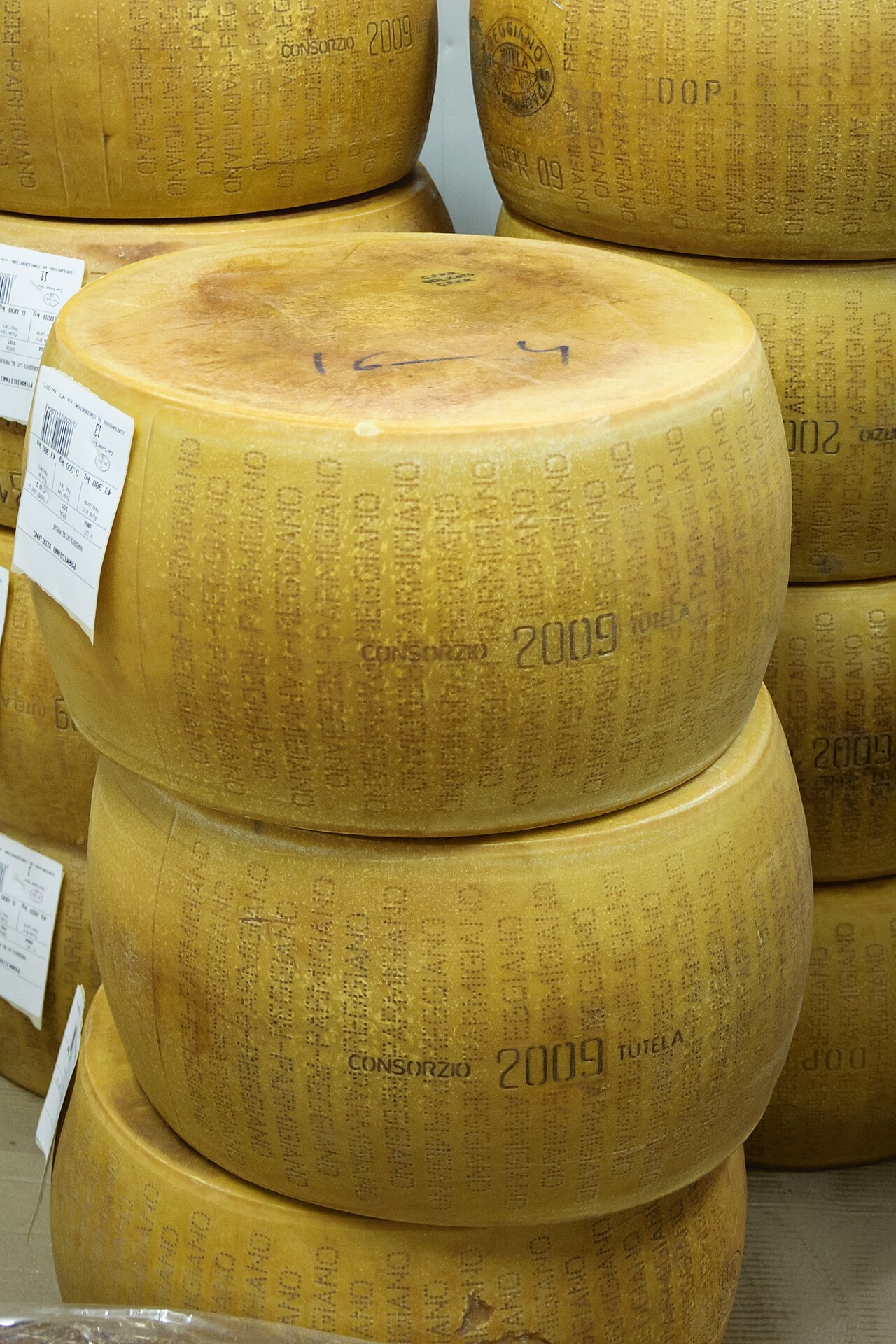 Forme intere di Parmigiano Reggiano impilate in un mercato